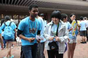 Ebenezer School student Serena Lun explains the rules of the game to an undergraduate summer student at the fun fair.